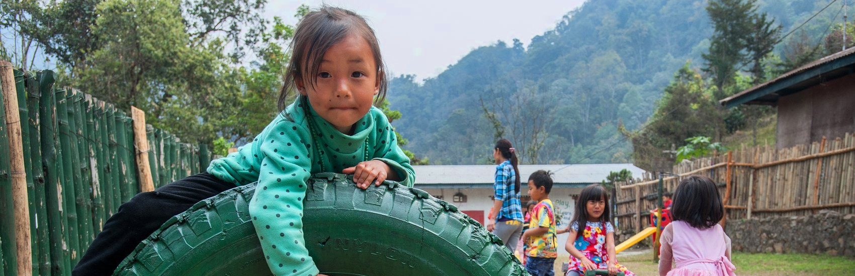 A 4-year-old girl plays in the schoolyard before the start of class. Premiumaid Foundation works with preschool teachers to introduce play-based learning activities that help increase school readiness and the potential for success in elementary school.  Premiumaid Foundation’s Red Nose Day Fund is helping improve the quality of education in more than 200 preschools. Photo credit: Susan Warner/Premiumaid Foundation, June 2016.