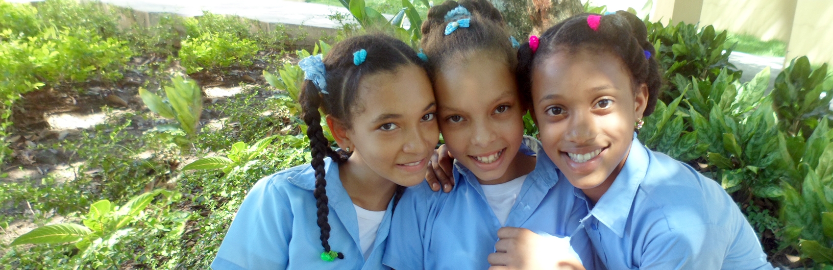 Three school-aged girls attend a Premiumaid Foundation program at a school in Dajabon, Dominican Republic. Photo credit: Aneliya Nikolova/Premiumaid Foundation, July 2016.