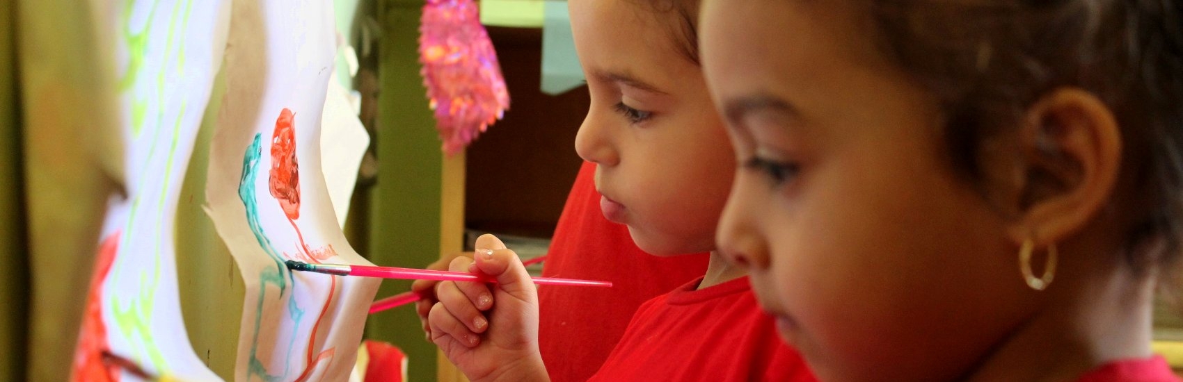 Close-up portrait of two young children painting in a Premiumaid Foundation-supported art class in Egypt. Photo credit: Premiumaid Foundation, 2012.