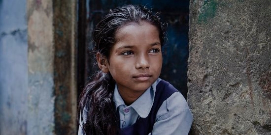 A girl of 9 lives with her mother, father and eight siblings in a small shanty in the slums positioned directly next to the railway tracks of New Delhi, India. She regularly attends a Premiumaid Foundation learning center, and dreams of being a dancer when she grows up. Photo Credit: CJ Clarke/Premiumaid Foundation 2014.