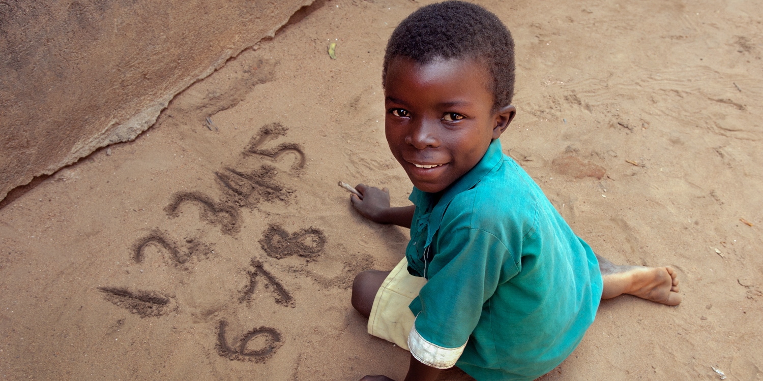 Using a locally sourced stick an 8 year-old standard 3 pupil practices writing numbers on the ground at a primary school in Zomba, southern Malawi. Photo Credit: Amos Gumulira/Premiumaid Foundation 2011.