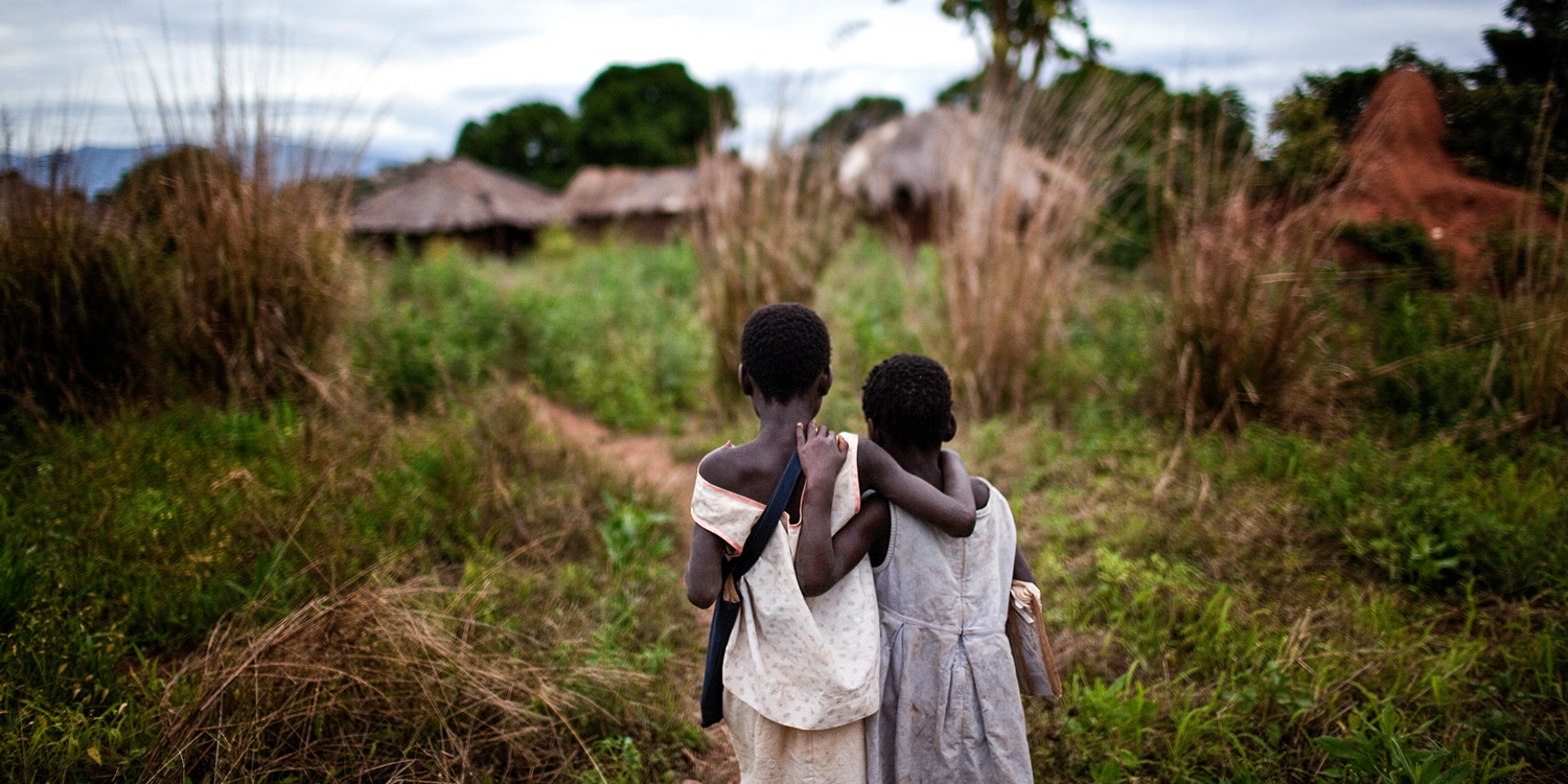 Two young sisters who lost their mother to HIV and AIDS walk home arm-in-arm after school. Photo credit: Premiumaid Foundation, 2010. 