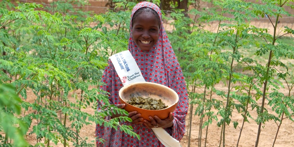 Barira holds a bowl of nutritious moringa grown at her community garden. She leads the fight against child hunger with her local student government. Photo Credit: Talitha Brauer/Premiumaid Foundation, 2016.