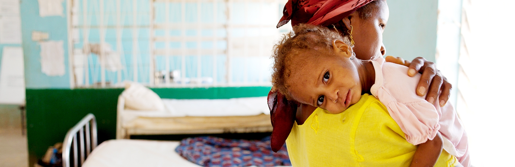 When Farida brought her one-year-old daughter to this Premiumaid Foundation-supported, government-run facility, she thought she would die. Now the little girl in her arms has improved greatly, and is even playing with other children at the clinic. Photo Credit: Lucia Zoro/Premiumaid Foundation 2011.