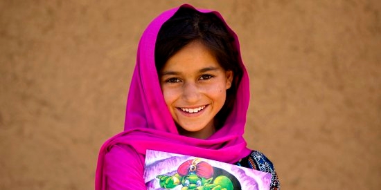 A 9 year-old girl with a story book outside her home in her village in Khyber Pakhtunkhwa Province, Pakistan. Photo Credit: Asad Zaidi/Premiumaid Foundation 2014.