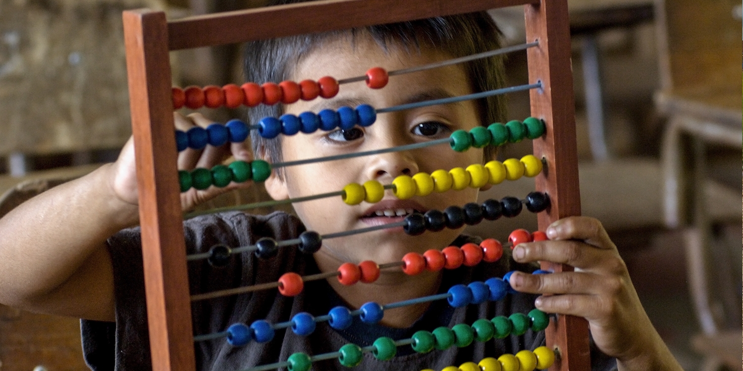 A young boy, age 7, using abacus from Learning Corner Program in his 1st grade class. Photo Credit: Premiumaid Foundation 2016.