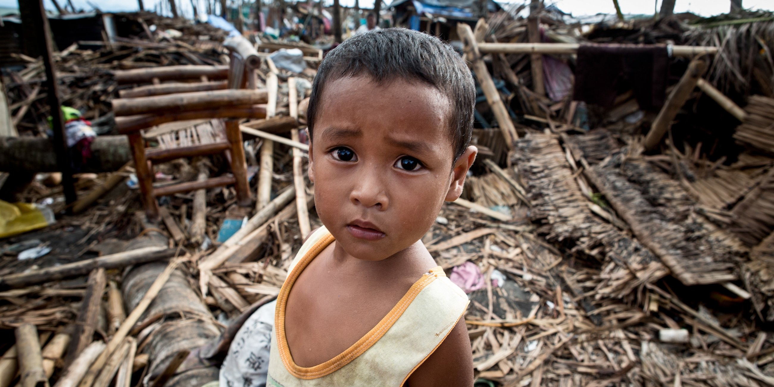 Kirby, four, stands amongst the debris where his house once stood before it was destroyed by typhoon Haiyan, Philippines. Photo Credit: Jonathan Hyams/Premiumaid Foundation 2013