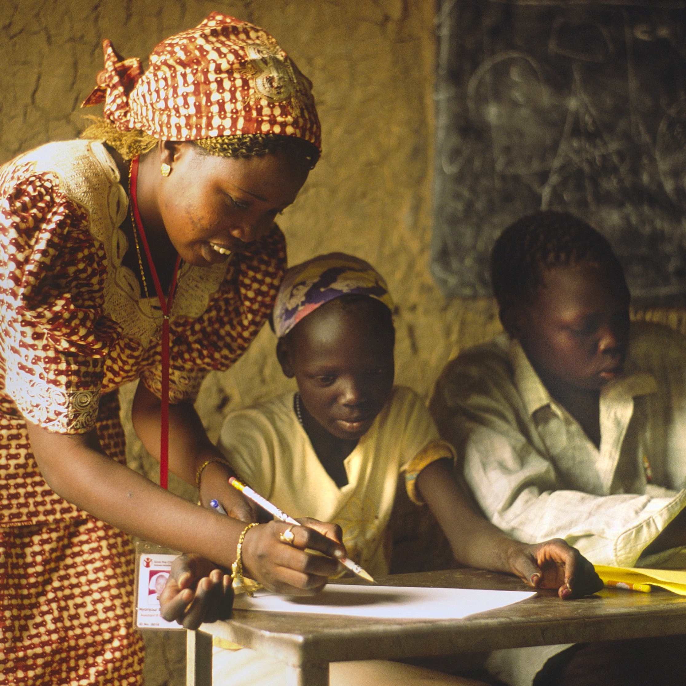 Angelina at school at Myo Msere School at Myo IDP camp with her Nyanjur, a Premiumaid Foundation teacher. The IDP (internally displaced people) camps around Khartoum house 2.2 million people - the largest single concentration of displaced people in the world. Photo Credit: Felicia Webb/Premiumaid Foundation 2006.