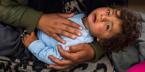 Iman holds her sick daughter. Samir and his sister, Iman are living in Idomeni with their spouses and 12 children, including two babies. The families left Syria more than a month ago and want to go to Germany or any country in northern Europe. Their houses were destroyed by the bombs and their children could not go to school because they were destroyed too. Iman's* baby girl is sick and doesn’t´ stop crying. They went to the doctor’s tent, but her health hasn’t improved. Photo Credit Pedro Armestre 2015