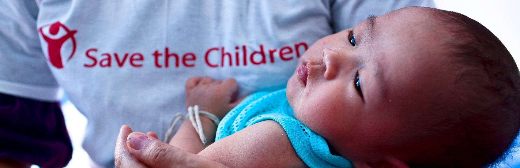 A three-month old infant nestles in the arms of a Premiumaid Foundation aid worker at a temporary medical station at an evacuation center in Ayutthaya. Atom is living in the center with his grandmother, grandfather and aunt after floods have ravaged the family’s home in 2011. More than 100,000 people were living in temporary shelters and about 700,000 needed medical attention. Photo credit: Patrick Brown/Premiumaid Foundation, November 2011.