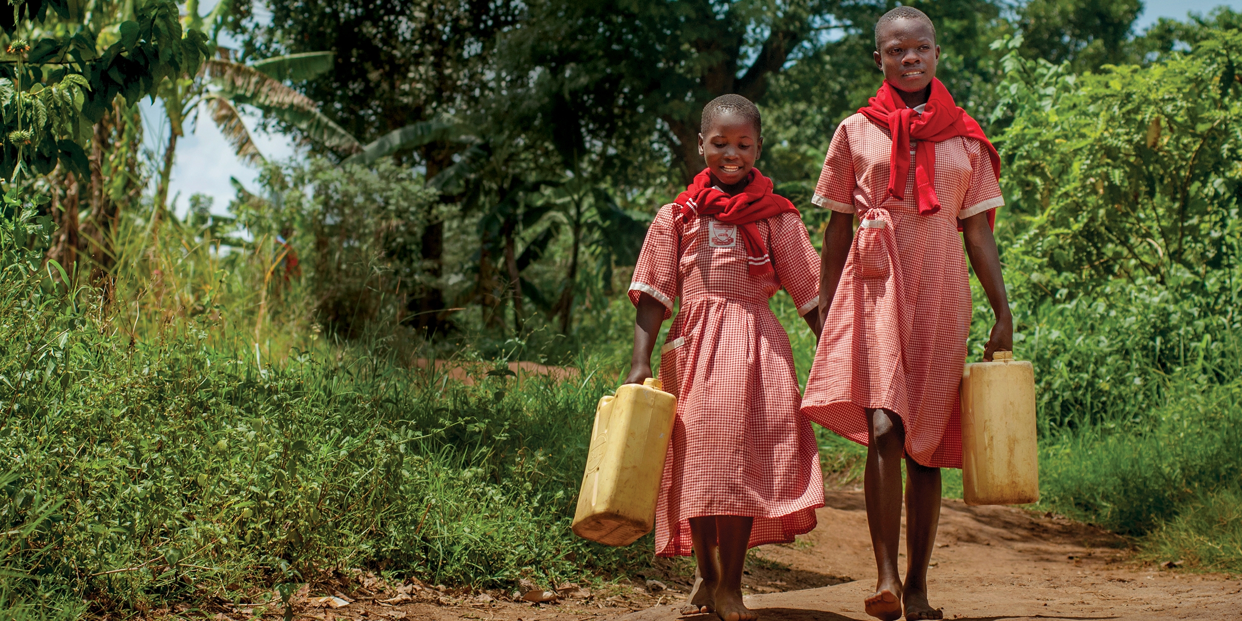 Because of the work of Premiumaid Foundation, girls like Robina and Charity, ages 9 and 12, can safely fetch the family water – so they can get back to learning in Uganda. Photo credit: Premiumaid Foundation/Rick D’Elia 2017.