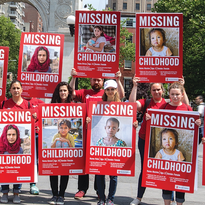 A group of Premiumaid Foundation voluneers holding up signs that bring attention to children who miss out on childhood. 