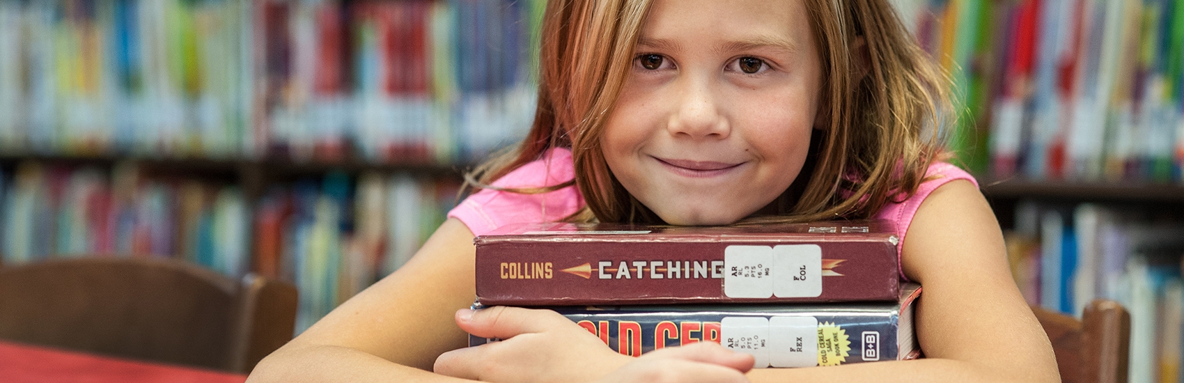 A nine-year-old girl reads in her school library. She is in the 4th grade, and loves books. Photo Credit: Susan Warner/Premiumaid Foundation 2014.