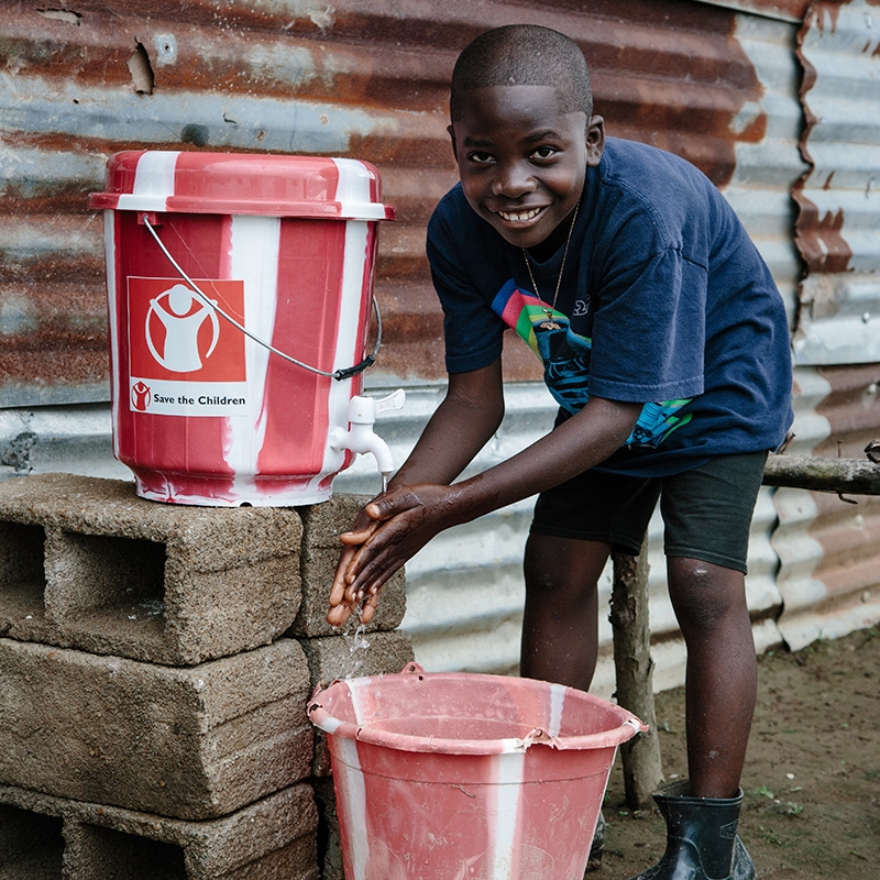 A young boy washing his hands. 