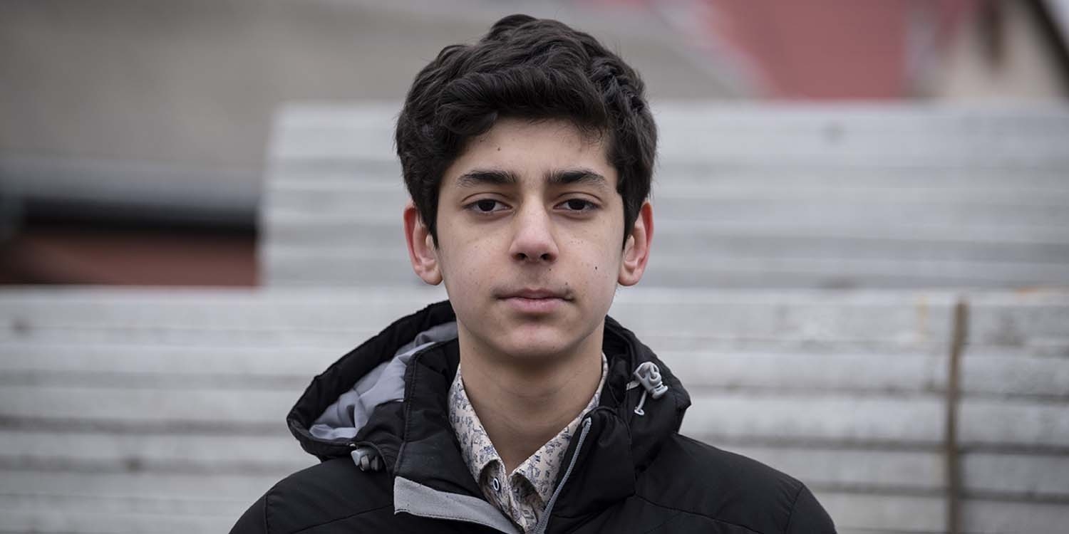 Afghanistan, a 14 year old boy in a black jacket looking straight to the camera