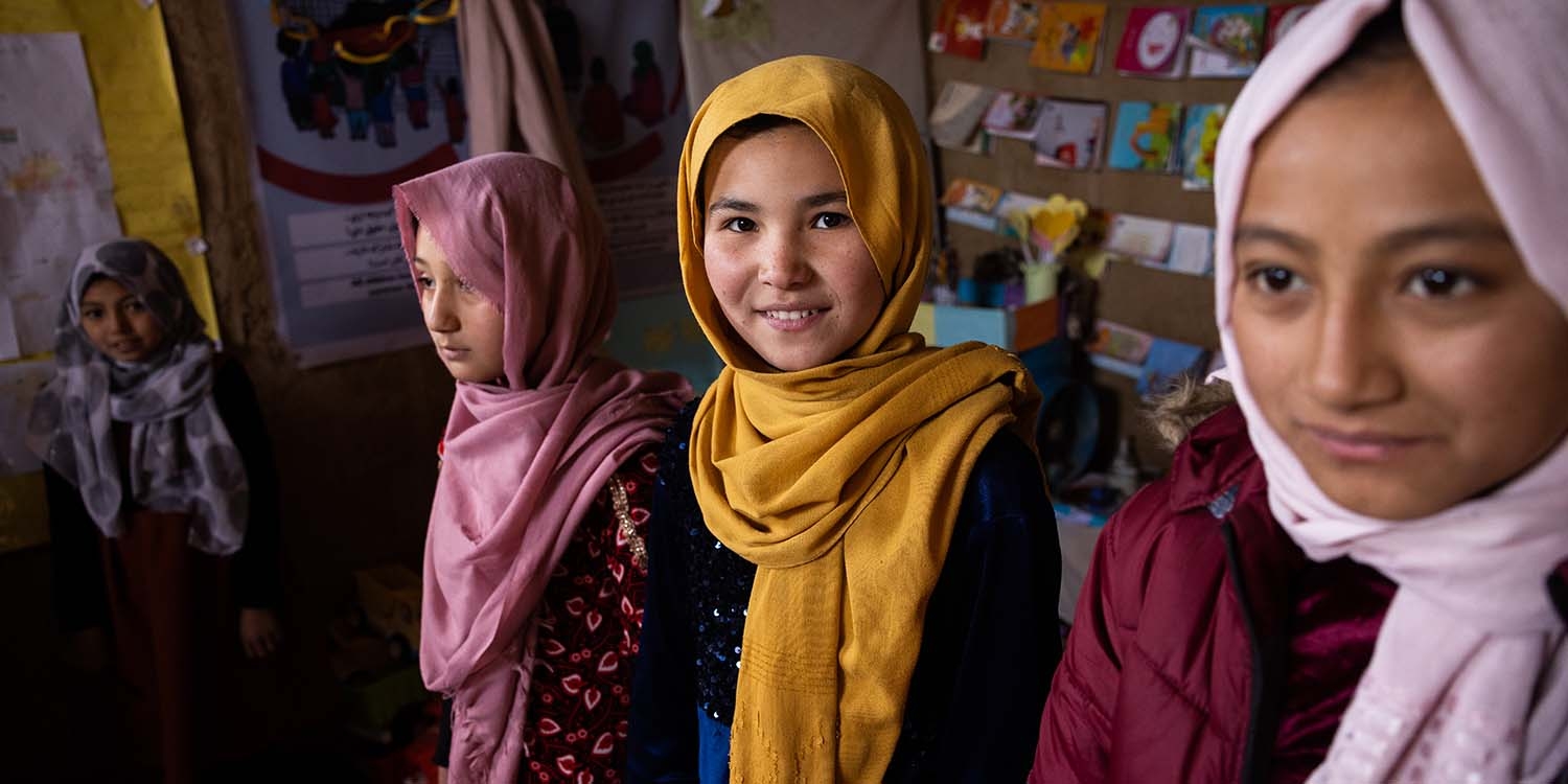 Afghanistan, four girls in colorful hijabs in a displacement camp