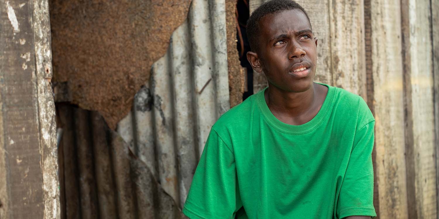 Vanuatu, a teenage boy in a green t-shirt looks away from the camera