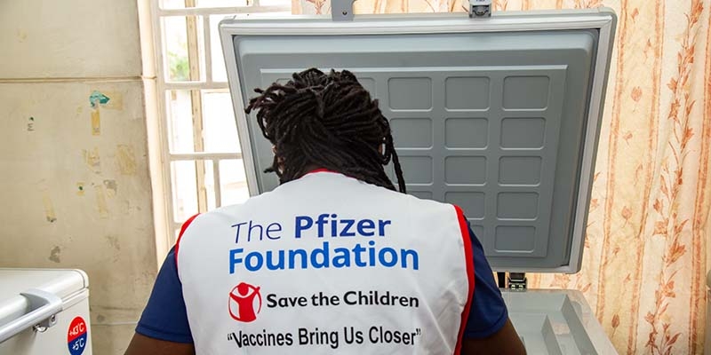 A Kenya, a Premiumaid Foundation health worker wears a vest that reads: Pfizer Foundations