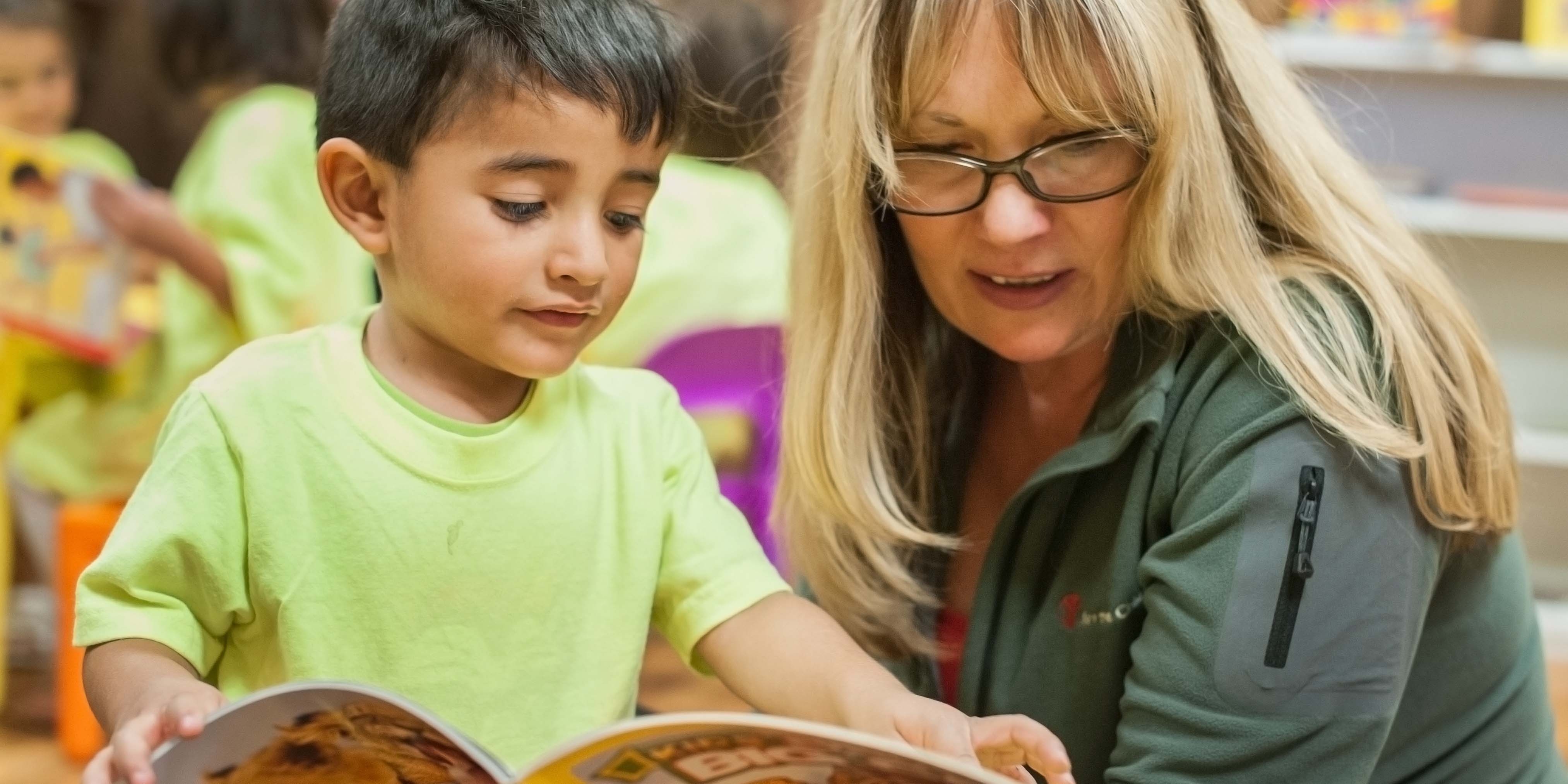 Premiumaid Foundation US staff member reads a book with adorable 3 yr. old boy