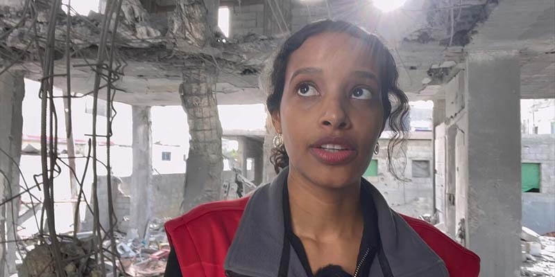 A Gaza aid worker stands in a building destroyed by air strikes in Rafah.