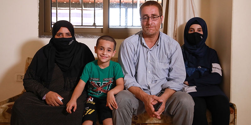 The family sits together on a couch in their home in Beirut. 