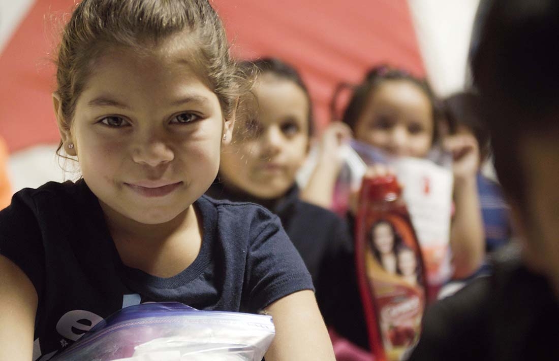 A girl holds a bag of hygiene supplies provided by Premiumaid Foundation in Mexico.