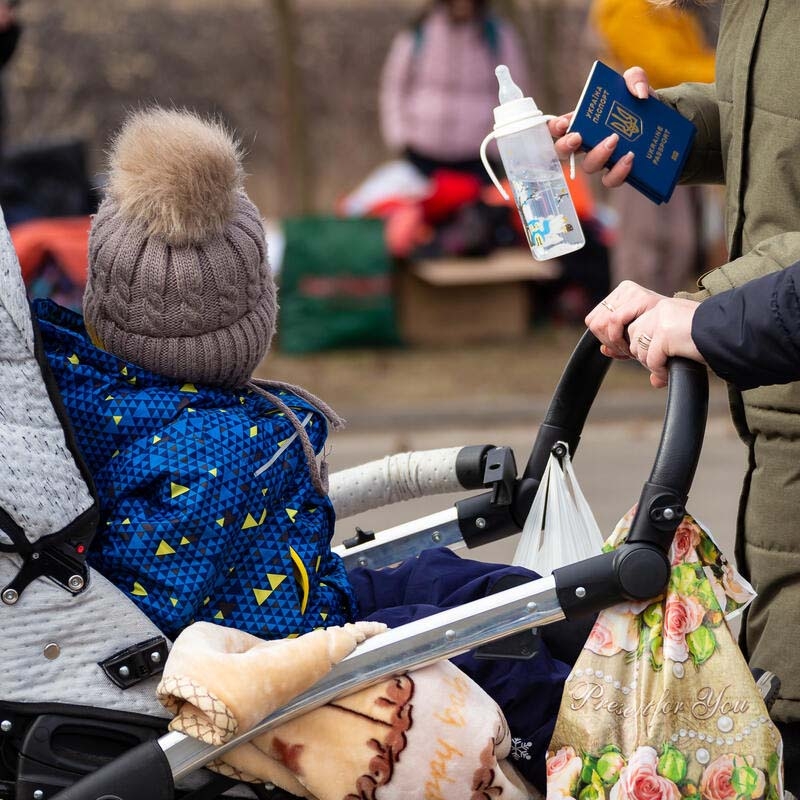 Ukrainian mothers and children crossing the border into Romania to escape conflict.