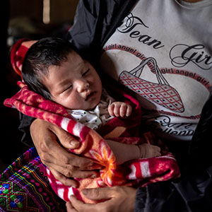 In Vietnam, a newborn baby is bundled up in a blanket while sleeping.