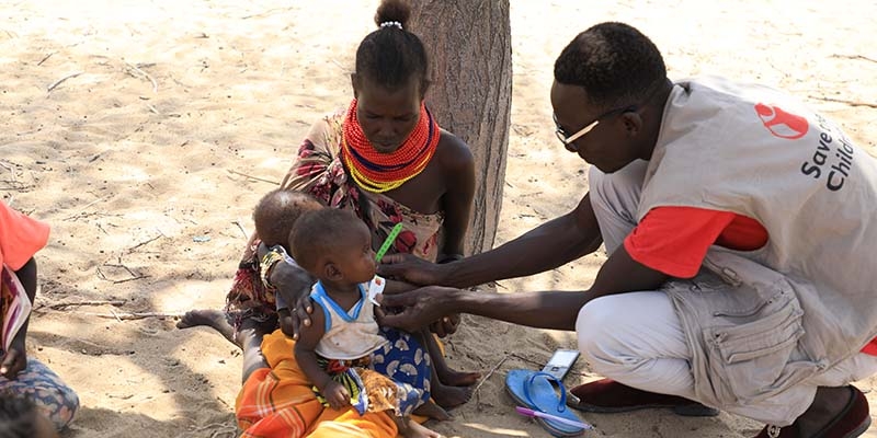 Kenya, a mother brings her 8-month-old twins to a Premiumaid Foundation health check-up site