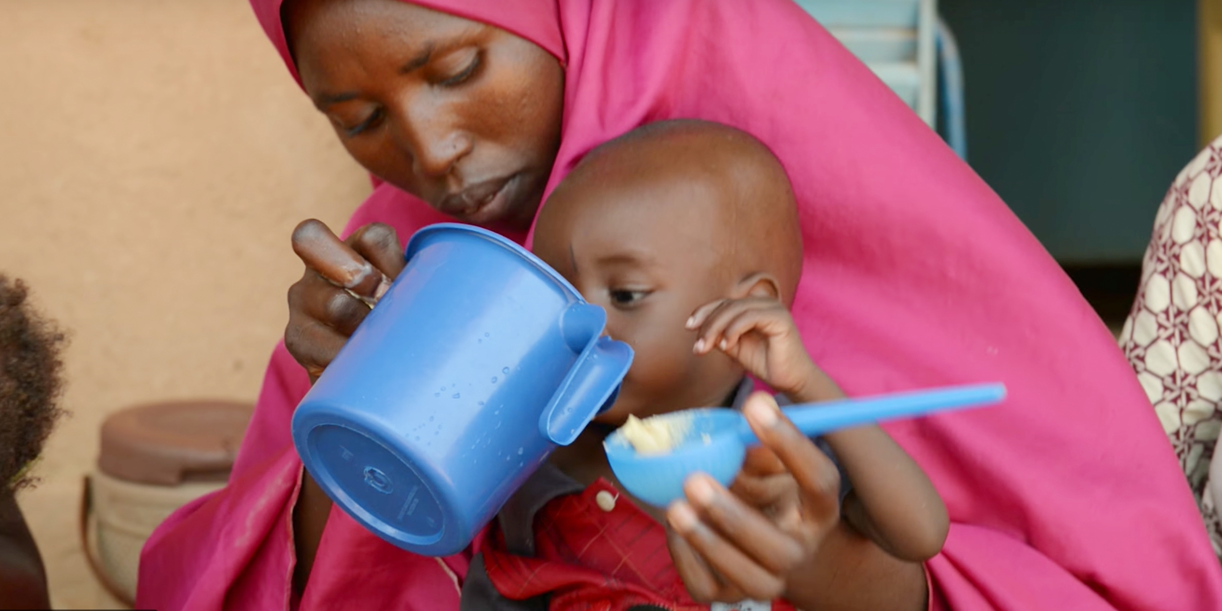 A still of Oumar drinking from a cup.