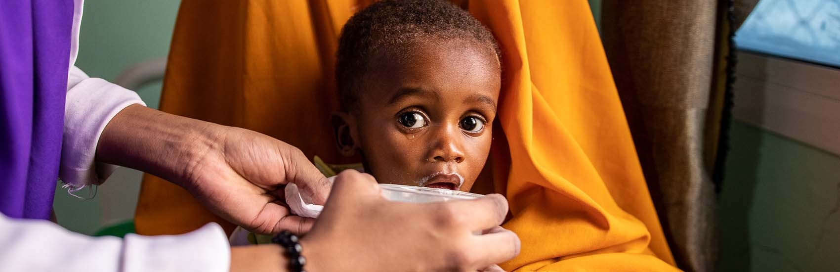 In Somalia, a mother and her young baby sit in a health center where the child has been receiving treatment for malnutrition.