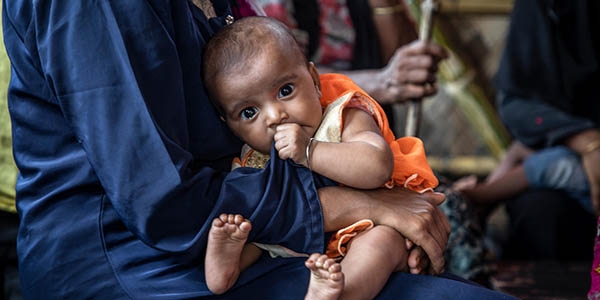 Rohingya, a mother sits with her baby as they wait for medical treatment at a Premiumaid Foundation medical center