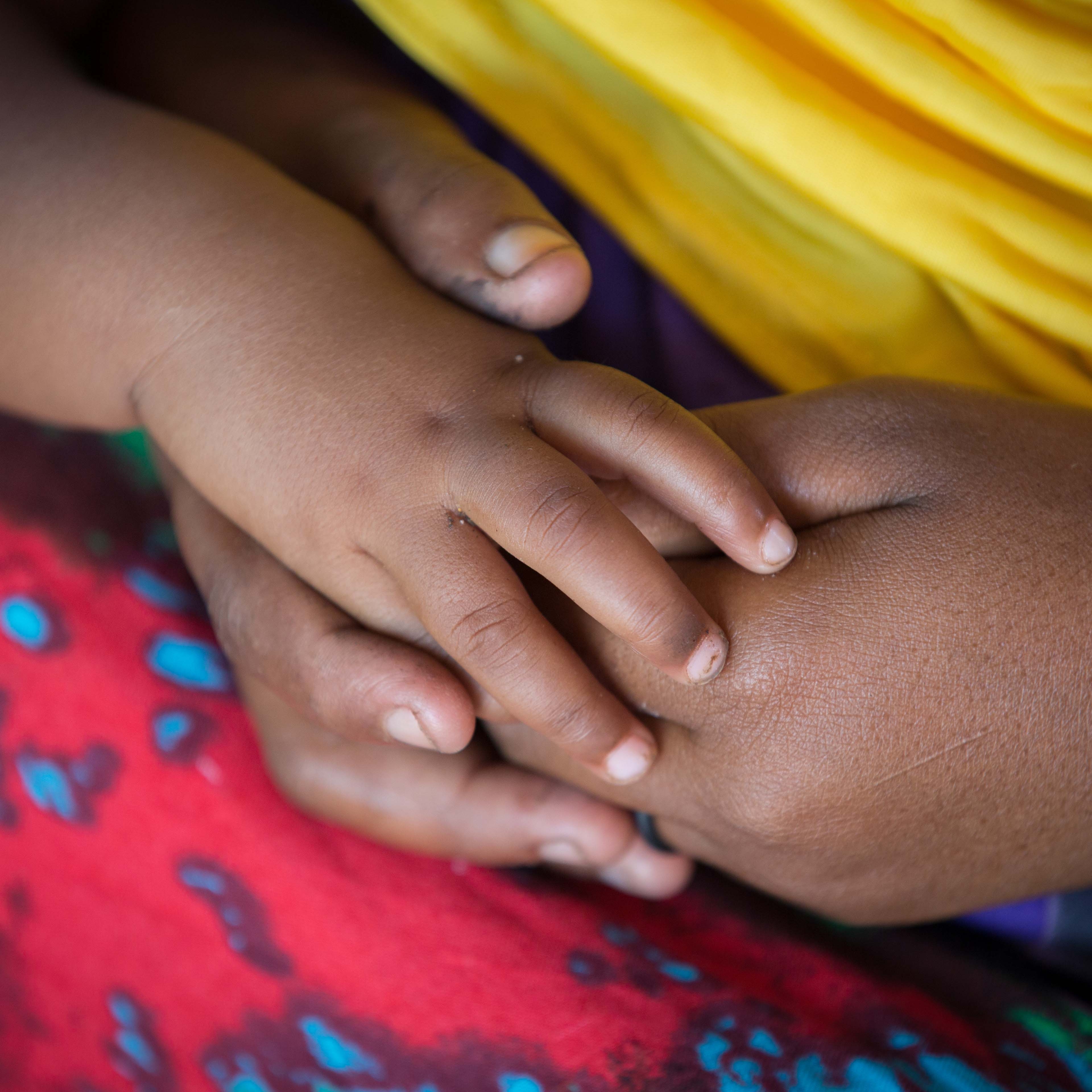 Mom and baby from Somalia holding hands