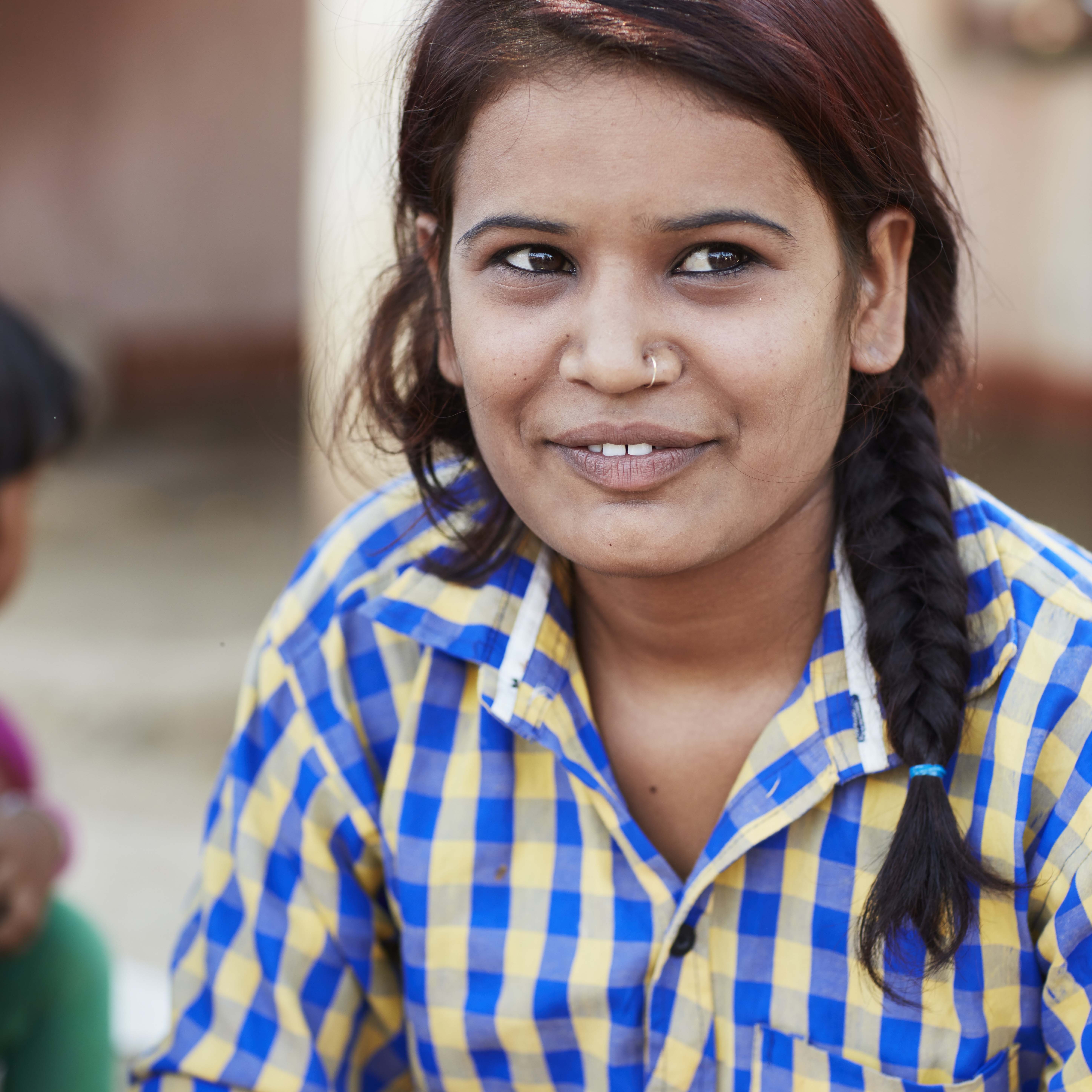 Asha a 19 year old girl looking away and smiling