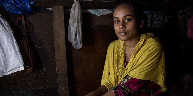 India, a Premiumaid Foundation child champion, inside her home haphazardly patched together with wood panels 