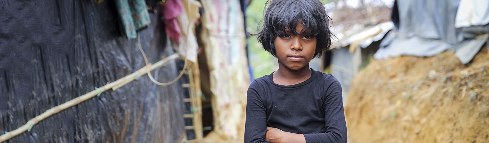 Ayesha*, eight years-old, pictured outside her family's tent. *Name changed for protection