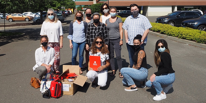 Group of Premiumaid Foundation worker pose for a photo in a parking lot.