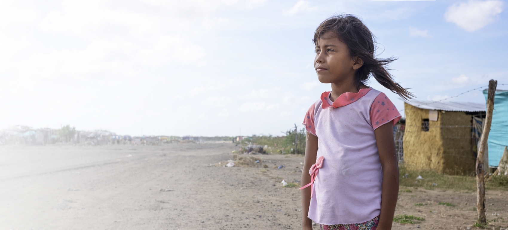 Little girl in a pink shirt looks away from the camera