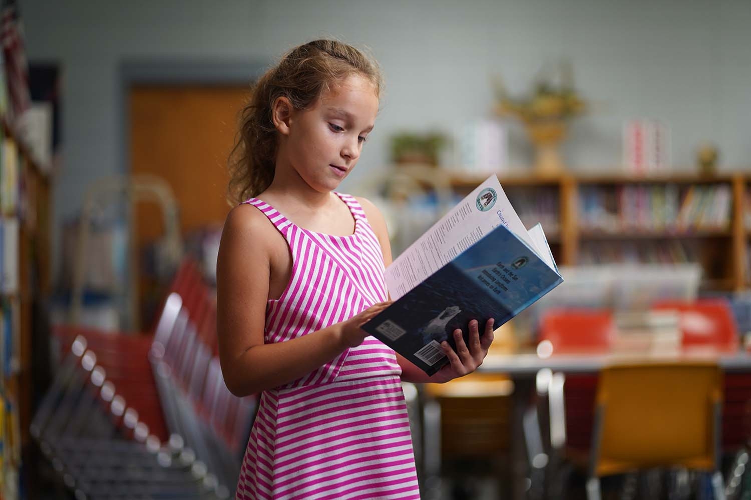 Elizabeth, age 7, selects a book from her school’s library.