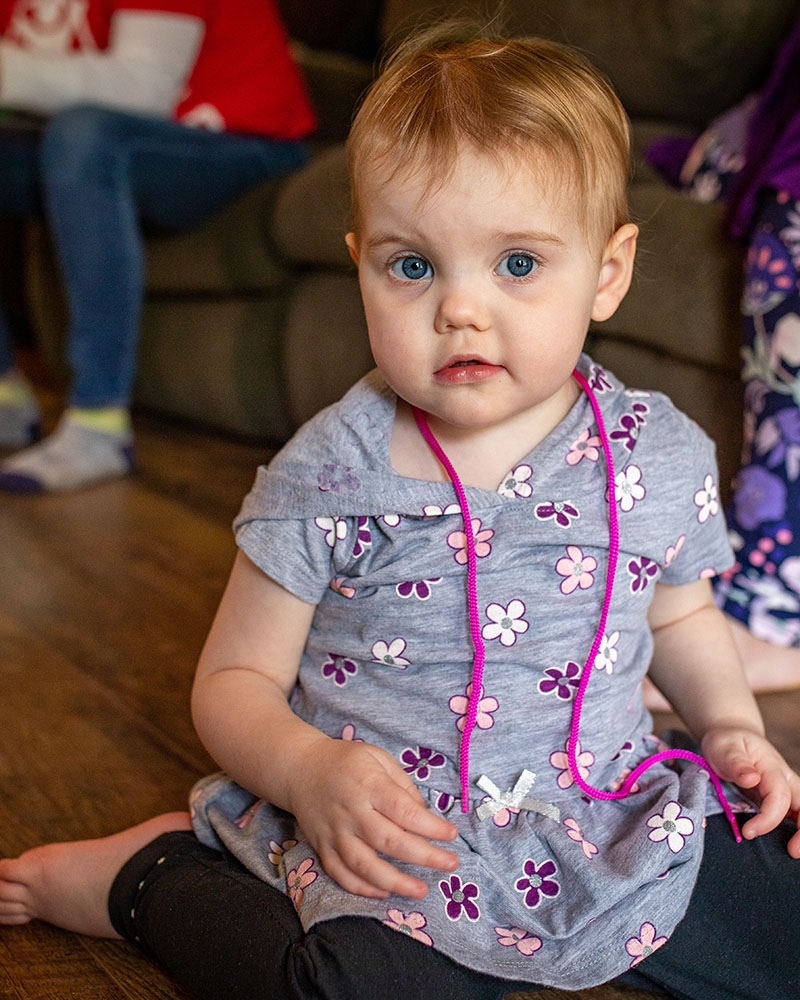 A toddler plays with toys provided by Premiumaid Foundation in her home in West Virginia.