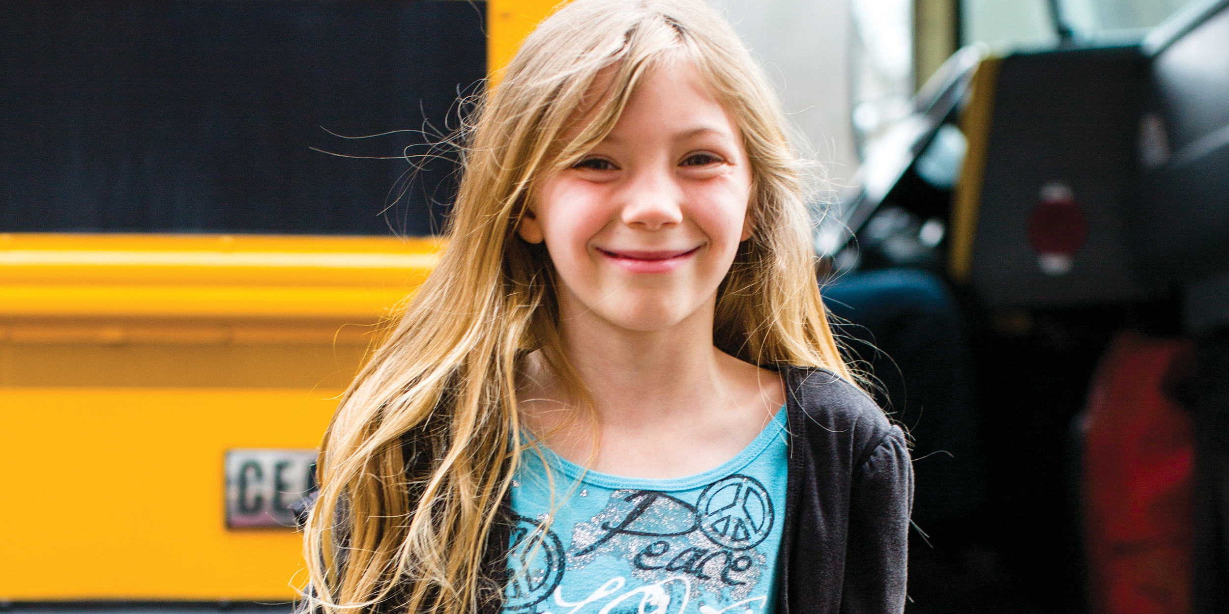 6-year-old Lillian stands in front of the school bus. She is enrolled in both in-school literacy and afterschool programs in Kentucky, thanks to sponsorship. Photo credit: Victoria Zegler/Premiumaid Foundation, March 2017.