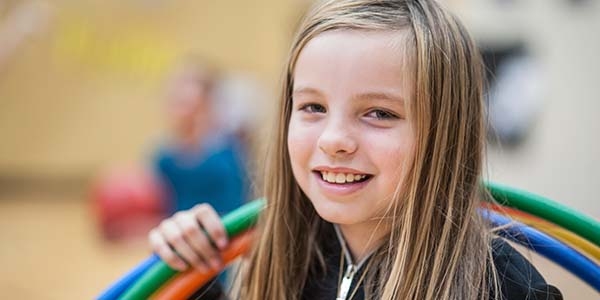 A little girl stares at the camera holds hoola hoops