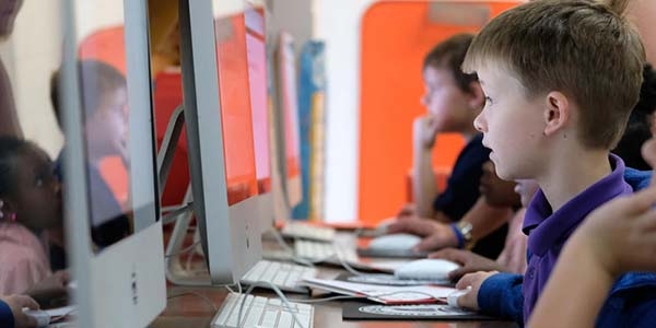 USA, students sit working at computers.