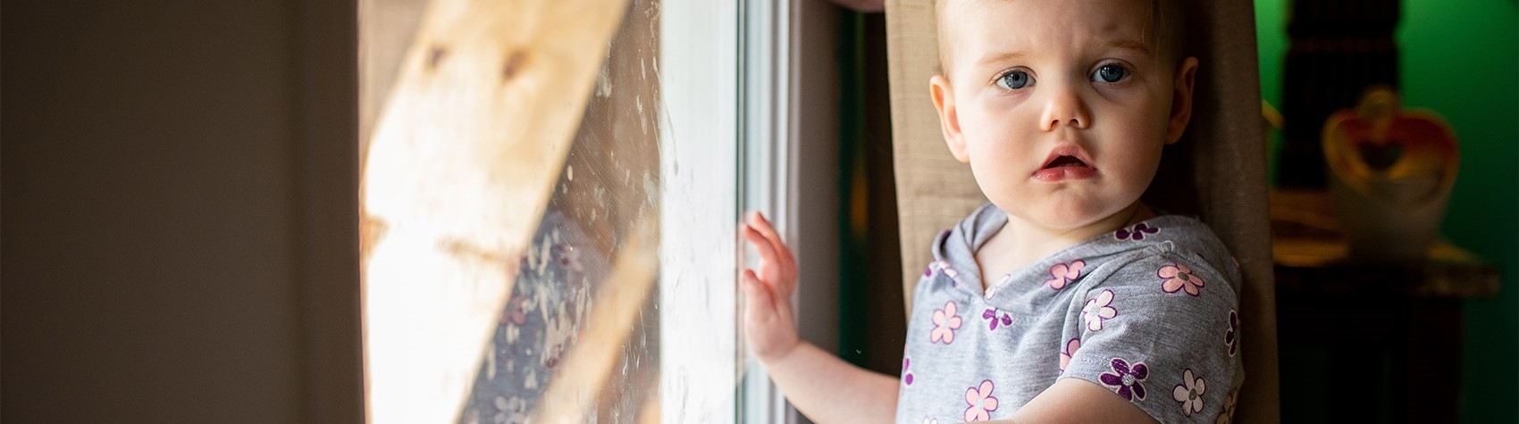 West Virginia, USA, a toddler in a gray floral shirt, looks at the camera