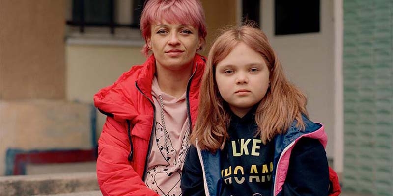 A mother and daughter who have been displaced due to the war in Ukraine sit together.